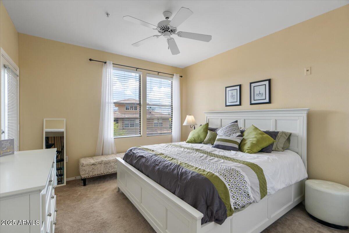 20100 North 78th Place, Unit 2203 Scottsdale, AZ 85255 - Photo 15 of 35 a bedroom with a bed and a chandelier