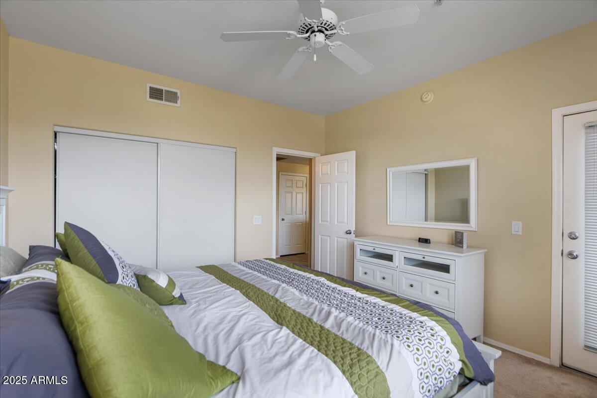 20100 North 78th Place, Unit 2203 Scottsdale, AZ 85255 - Photo 16 of 35 a bedroom with a bed and ceiling fan