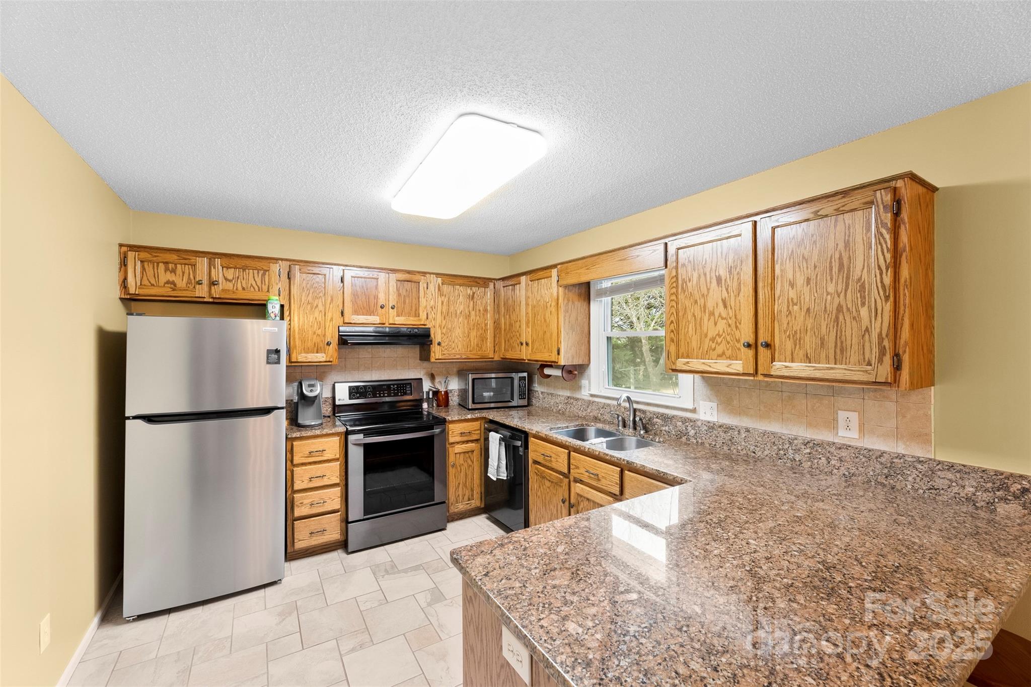 715 Deese Road Monroe, NC 28110 - Photo 11 of 28 a kitchen with stainless steel appliances granite countertop a refrigerator a stove and a sink with wooden floors