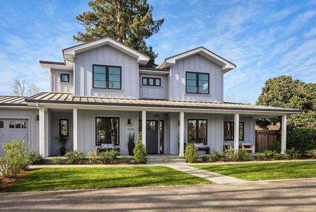 a view of a yard in front of a brick house with wooden walls