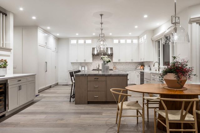 a kitchen with a table chairs sink and cabinets