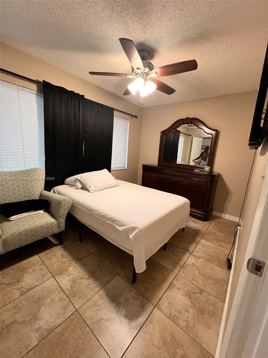 11394 Southwest 65th Street, Unit 1 Miami, FL 33173 - Photo 4 of 9 a bedroom with a bed and a chandelier