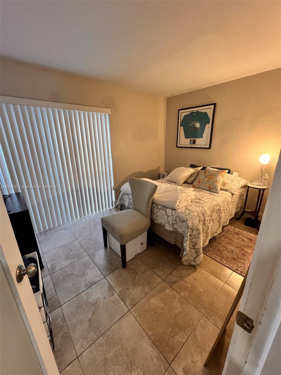 11394 Southwest 65th Street, Unit 1 Miami, FL 33173 - Photo 7 of 9 a bedroom with bed and window