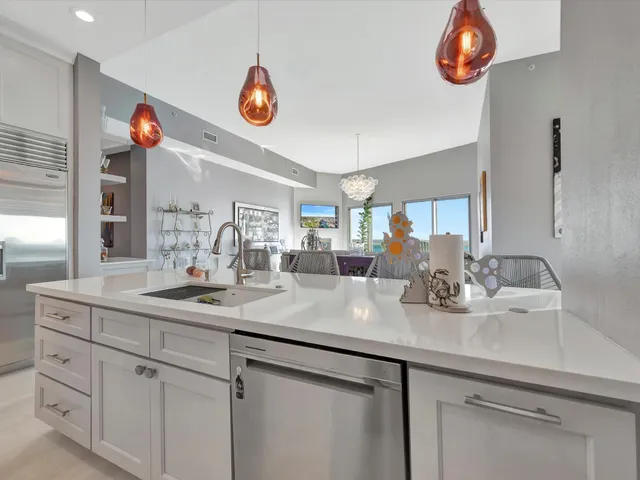 a kitchen with a sink dishwasher a stove and a refrigerator with wooden floor