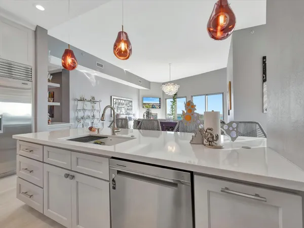 a kitchen with a sink dishwasher a stove and a refrigerator with wooden floor