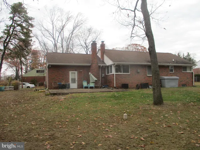 a view of a house with a yard and large tree