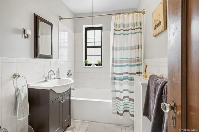 a bathroom with a sink a mirror a bathtub and shower