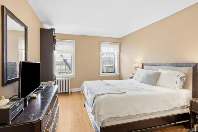 a bedroom with a bed window and a flat screen tv