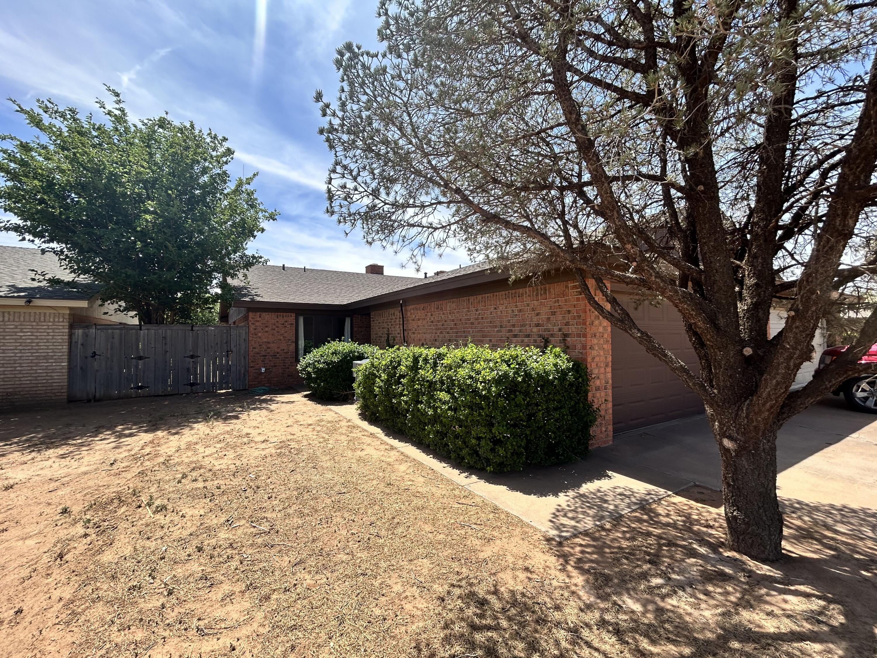 1115 80th Street, Unit A Lubbock, TX 79423 - Photo 1 of 16 a front view of a house with a yard