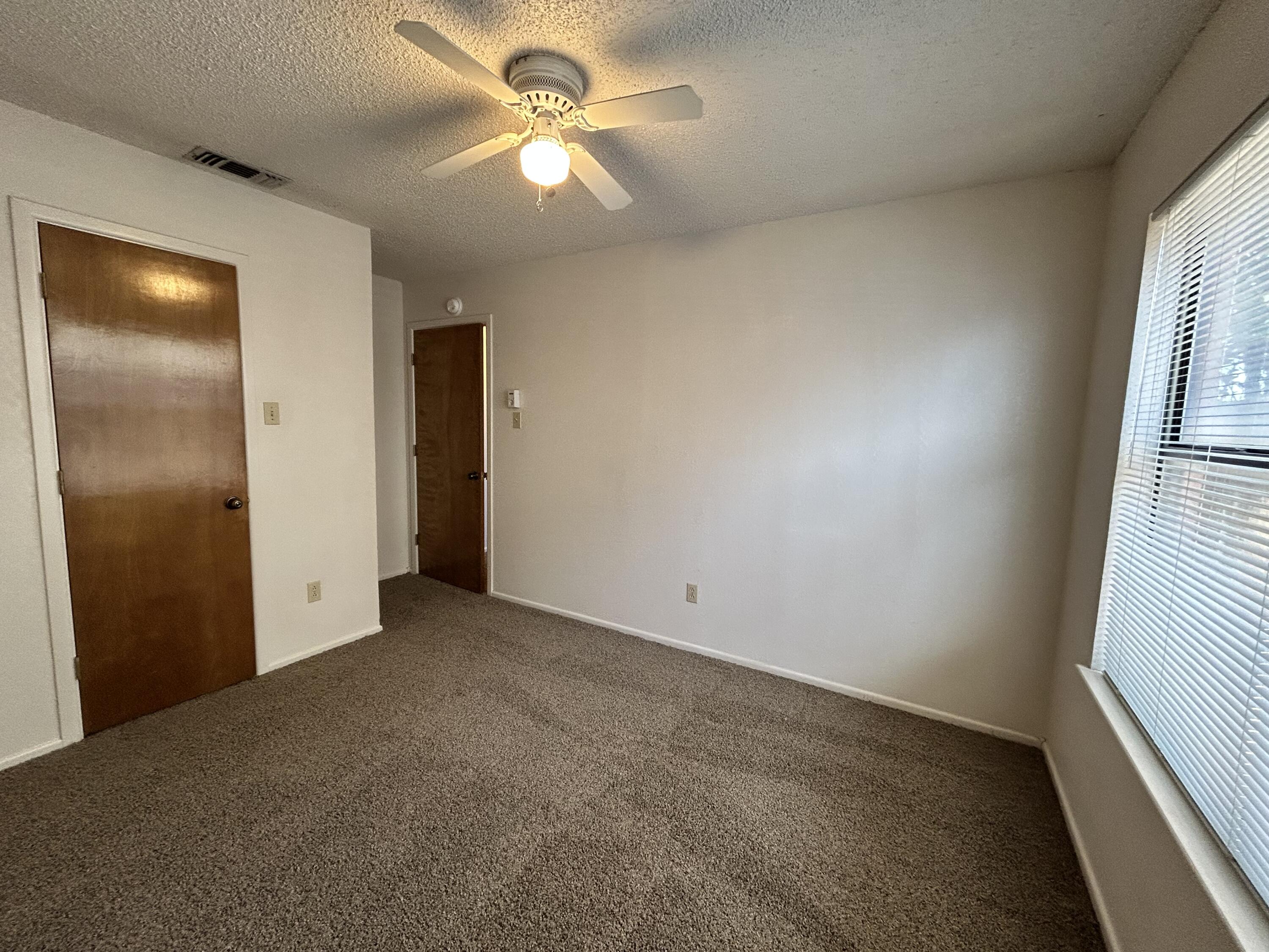 1115 80th Street, Unit A Lubbock, TX 79423 - Photo 14 of 16 an empty room with windows and fan