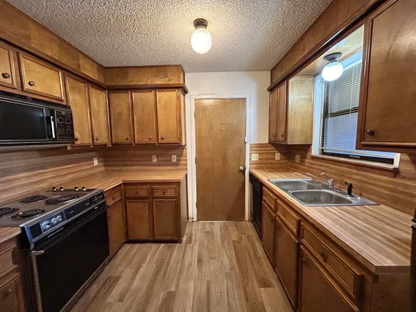 a kitchen with a stove a sink and a microwave