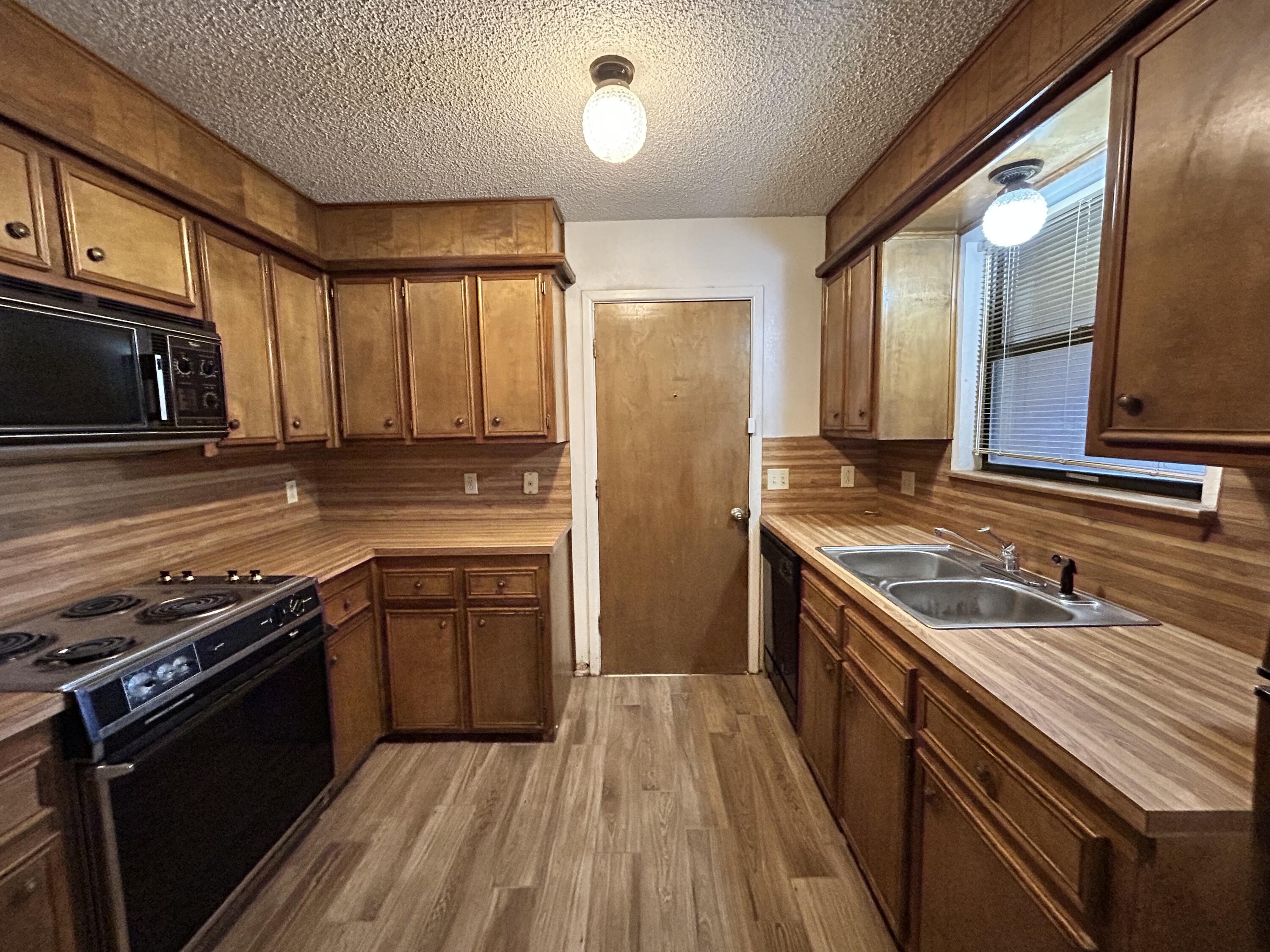 1115 80th Street, Unit A Lubbock, TX 79423 - Photo 4 of 16 a kitchen with a stove a sink and a microwave