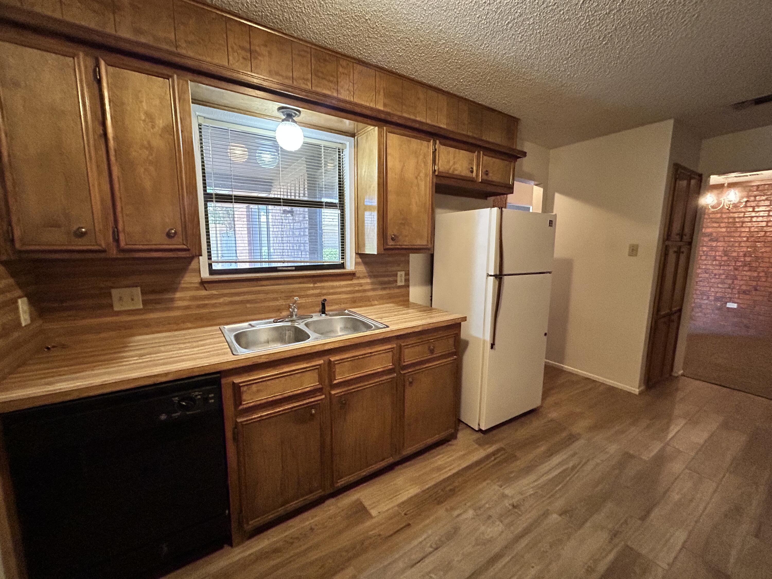 1115 80th Street, Unit A Lubbock, TX 79423 - Photo 5 of 16 a kitchen with a refrigerator sink and cabinets