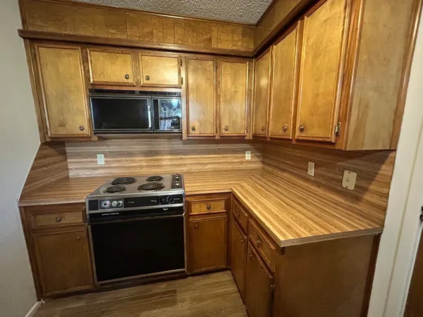 a kitchen with stainless steel appliances granite countertop a stove and a microwave