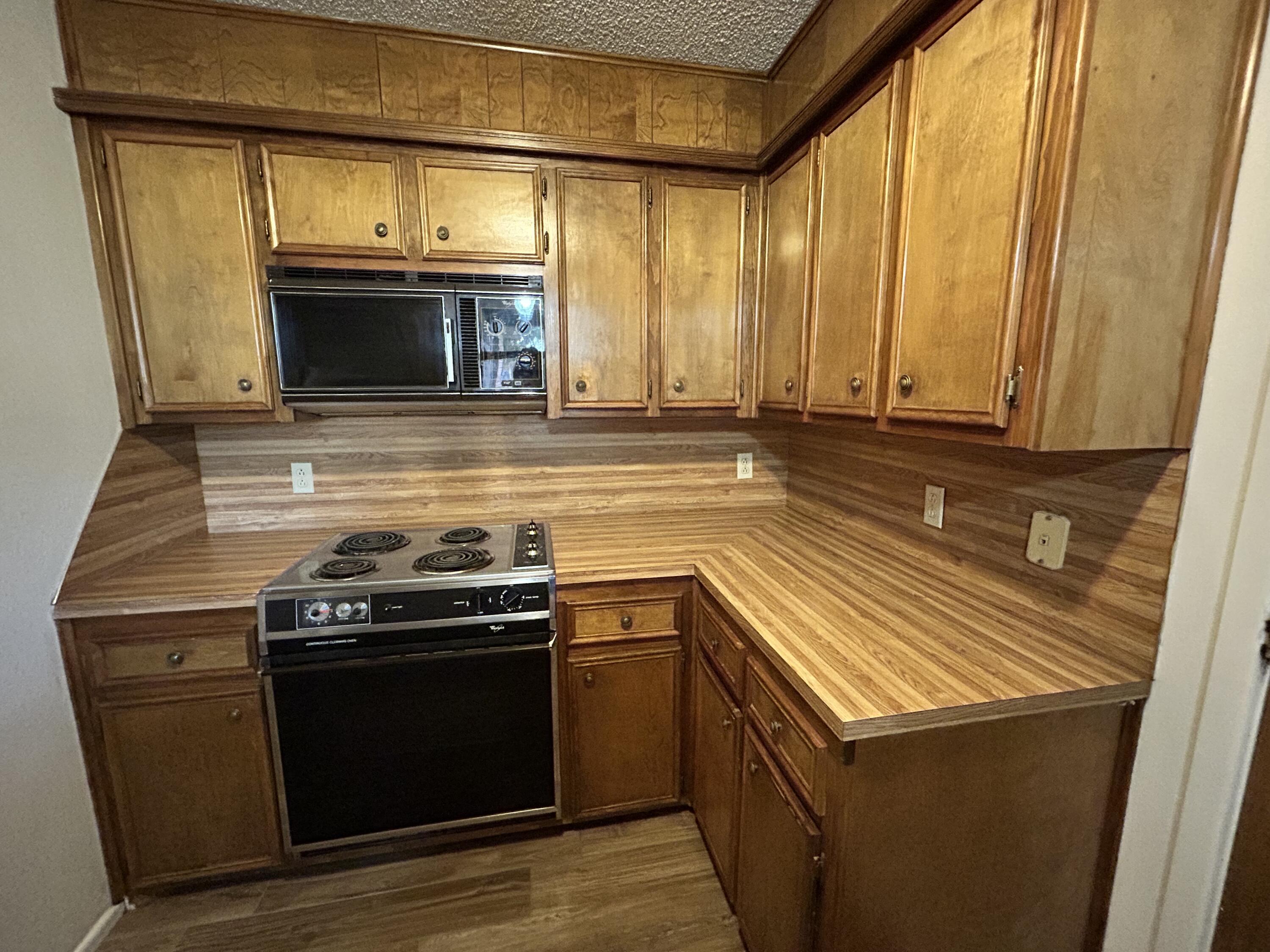 1115 80th Street, Unit A Lubbock, TX 79423 - Photo 6 of 16 a kitchen with stainless steel appliances granite countertop a stove and a microwave