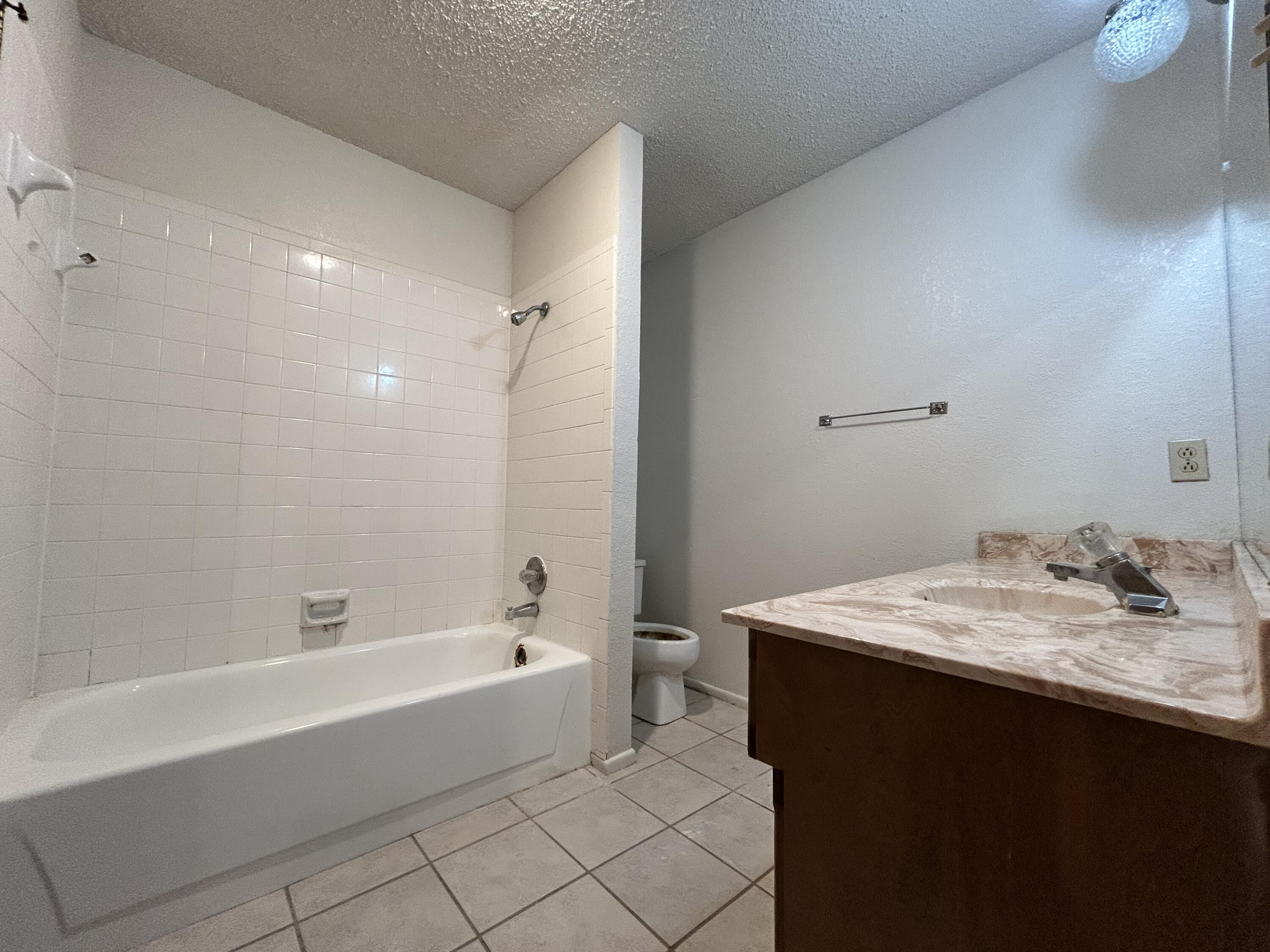 1115 80th Street, Unit A Lubbock, TX 79423 - Photo 10 of 16 a bathroom with a bathtub sink vanity and toilet
