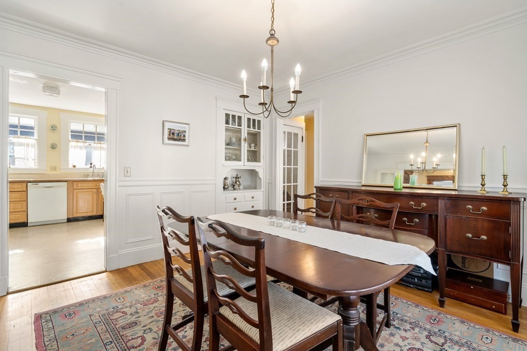 18 Fairfax Road Milton, MA 02186 - Photo 17 of 30 a dining room with wooden floor a chandelier a wooden table and chairs