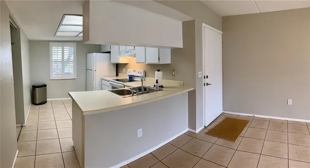 a kitchen with a sink a stove cabinets and a window
