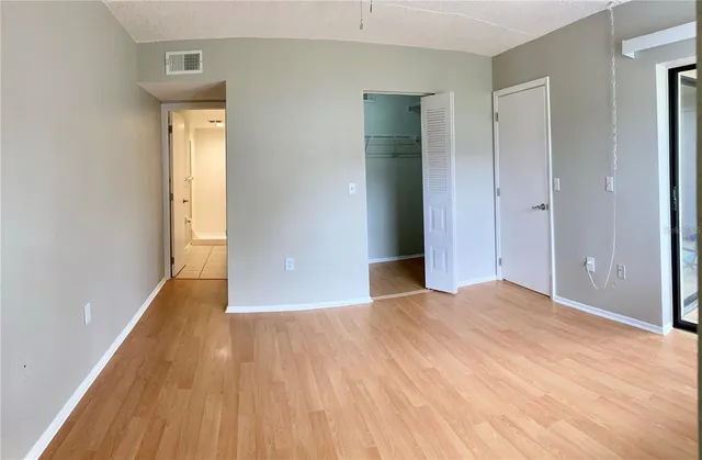a view of empty room with wooden floor
