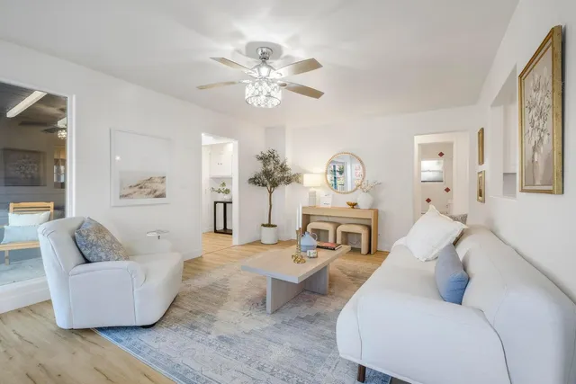 a living room with furniture and a chandelier
