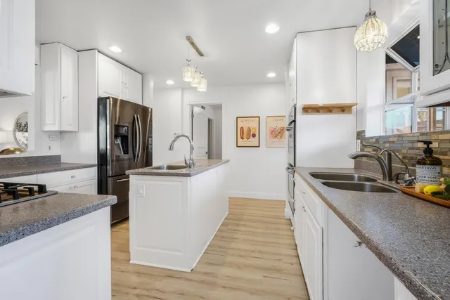 a kitchen with stainless steel appliances granite countertop a sink stove and refrigerator