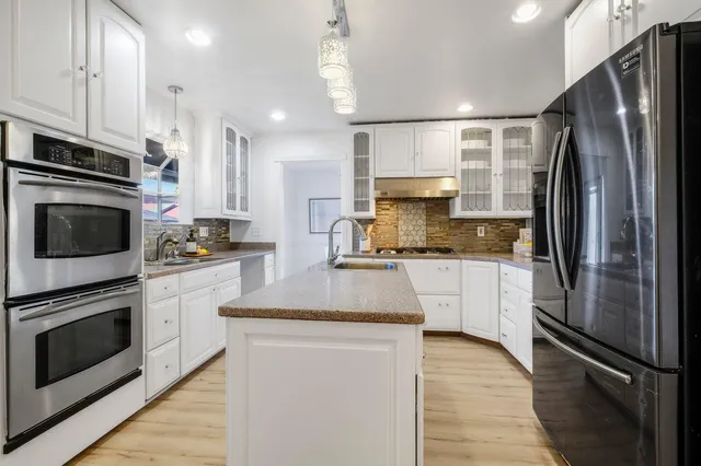 a kitchen with stainless steel appliances a refrigerator sink and microwave