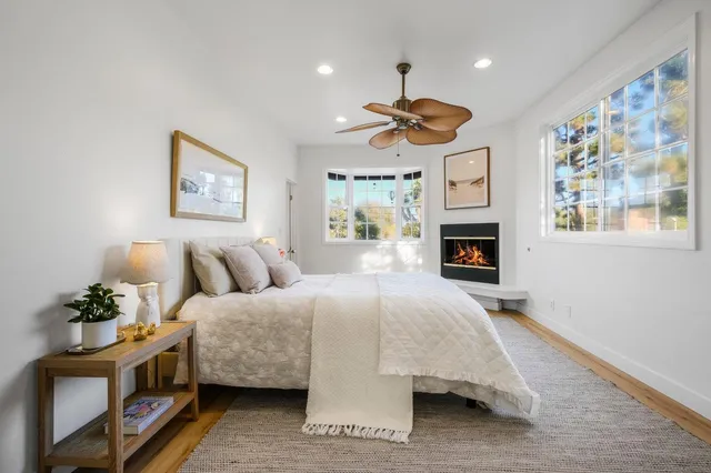 a spacious bedroom with a bed chandelier and a window