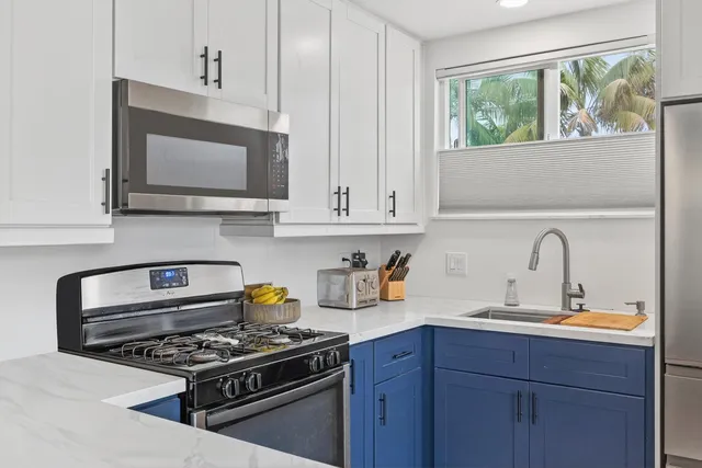 a kitchen with stainless steel appliances a stove a sink and a microwave