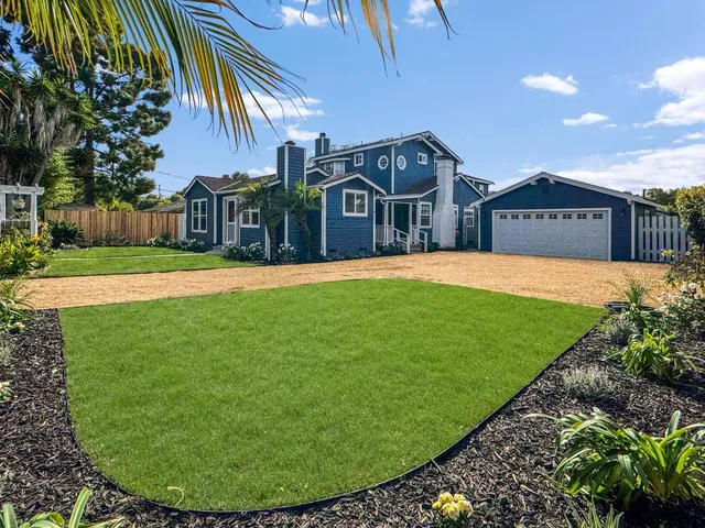 a view of a big house with a big yard and potted plants