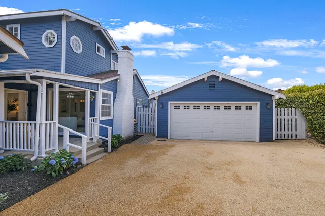 a view of a house with a yard and potted plants