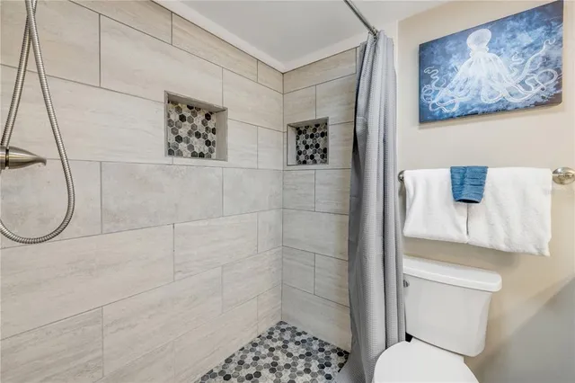 a view of a bedroom with a bed and wooden floor