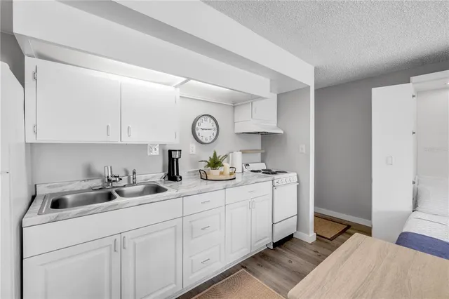 a kitchen with a sink a stove and cabinets