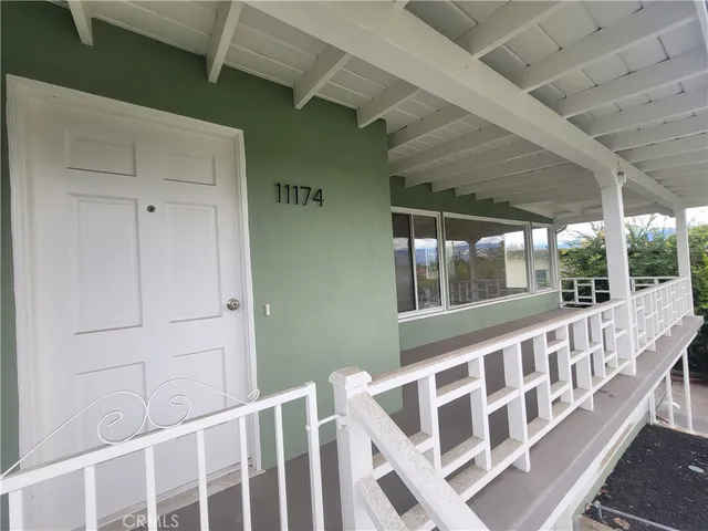 a view of wooden house with a porch