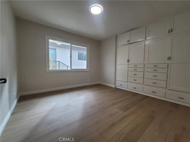 an empty room with cabinet and windows