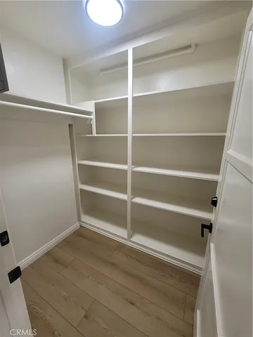 a view of walk in closet with empty racks