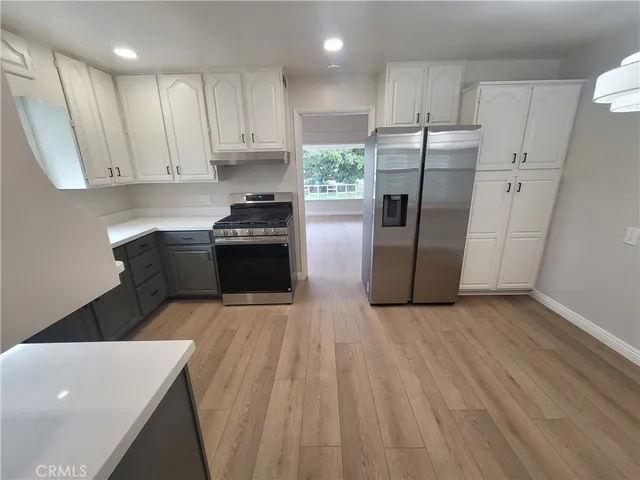 a kitchen with a sink a refrigerator and a stove top oven