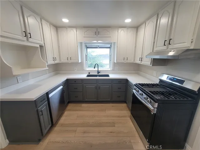 a kitchen with stainless steel appliances granite countertop a sink a stove and a refrigerator