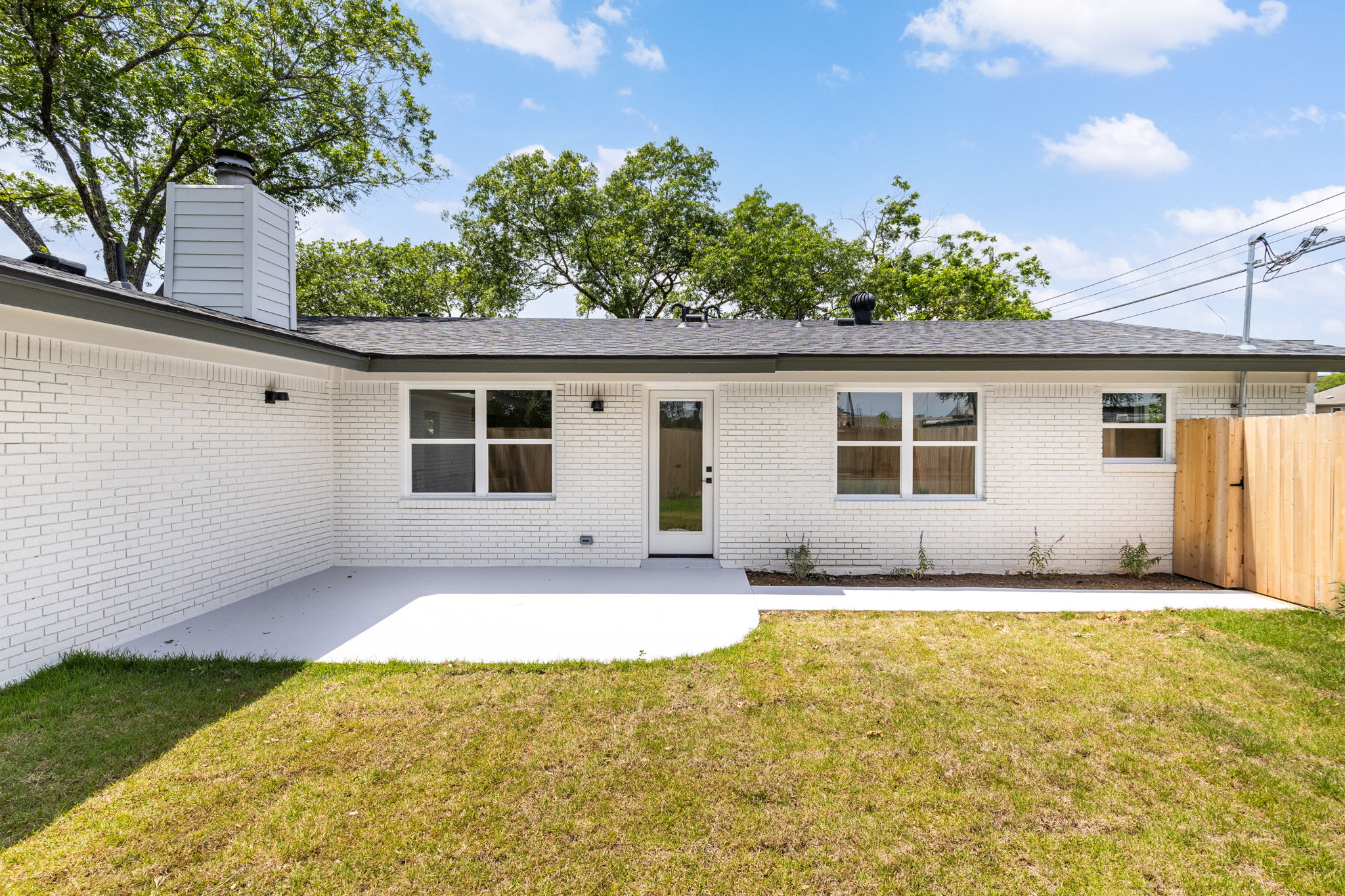 4501 Pack Saddle Pass Austin, TX 78745 - Photo 9 of 37 Rear exterior with white painted brick, dark gray trim, and a shingled roof