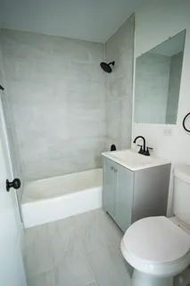 a white toilet sitting next to a bath tub