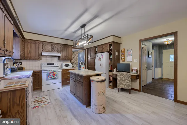 a large kitchen with cabinets wooden floor and stainless steel appliances