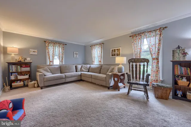 a living room with furniture and a book shelf