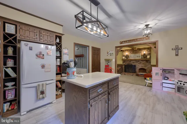 a kitchen with kitchen island a wooden floor and refrigerator