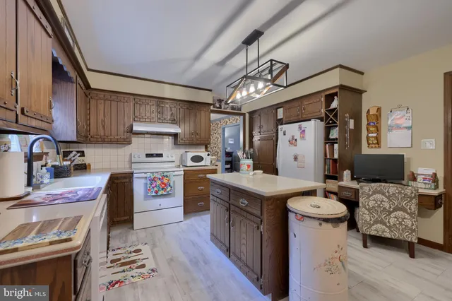 a kitchen with granite countertop a sink stove and refrigerator