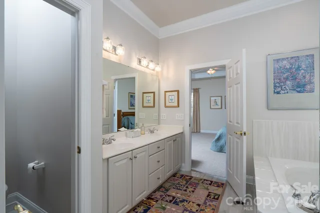 a spacious bathroom with a double vanity sink a mirror and a toilet