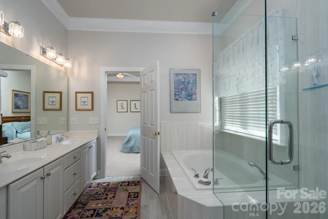 a spacious bathroom with a double vanity sink a mirror and a shower