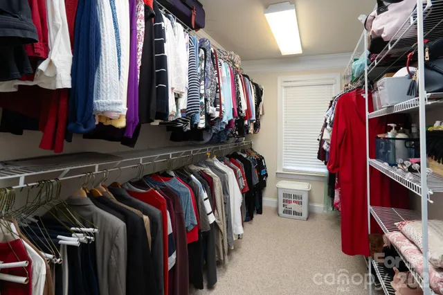 a view of walk in closet with clothes and shoes