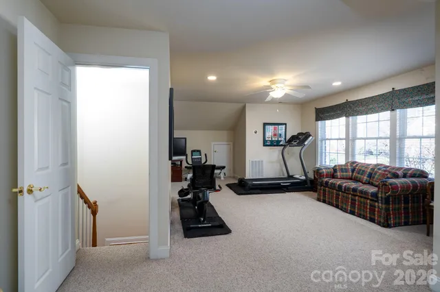 a living room with furniture gym equipment and a large window