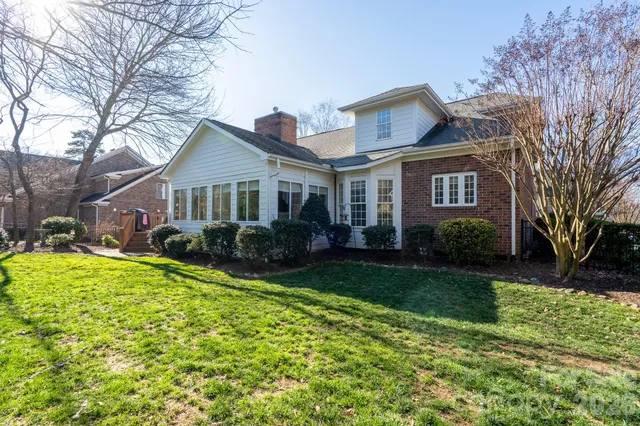 a front view of a house with a yard and trees