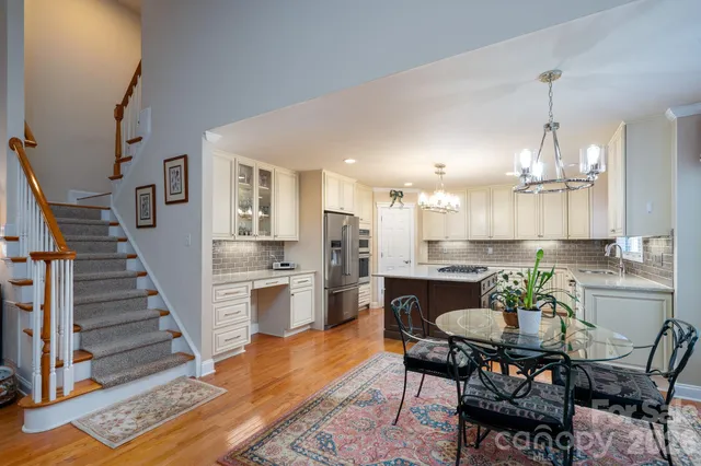 a view of a dining room with furniture a rug and wooden floor