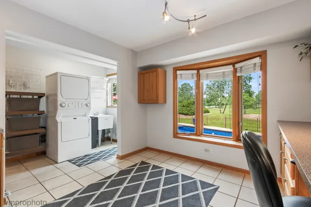 a open kitchen with stainless steel appliances granite countertop a stove a sink and a dining table with wooden floor